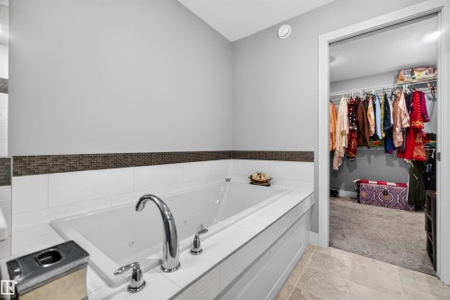Built-in bathtub with polished chrome fixtures and white tiled surround - 1603 158 Street, Edmonton, AB 