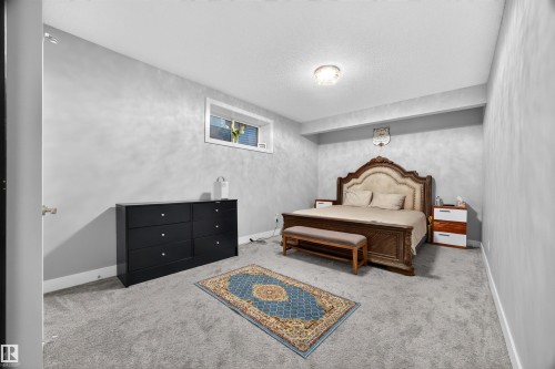 Carpeted bedroom with a small window, light gray walls, and recessed lighting - 1603 158 Street, Edmonton, AB 