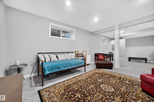 Spacious room featuring light gray walls, recessed lighting, and gray carpet flooring - 1603 158 Street, Edmonton, AB 