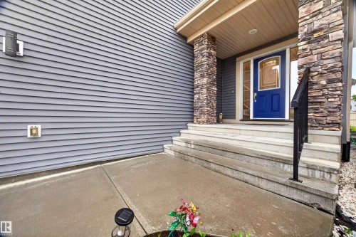 Inviting entry with a vibrant blue door, sidelight windows, and decorative glass - 1603 158 Street, Edmonton, AB 