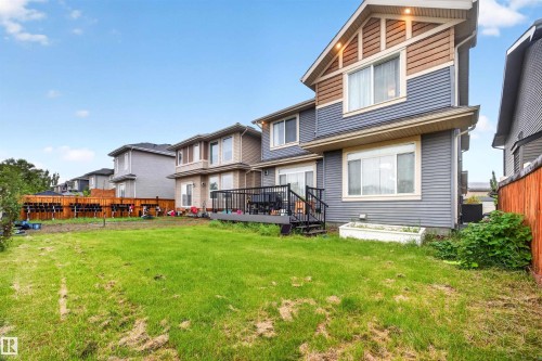Rear exterior with multi-level siding and trim, featuring a ground-level patio door and an upper-level window - 1603 158 Street, Edmonton, AB 