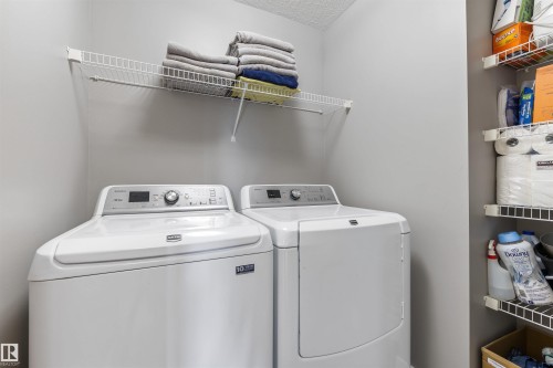 Dedicated laundry area featuring a white top-load washing machine and a white front-load dryer - 1651 Hammond Crescent, Edmonton, AB 