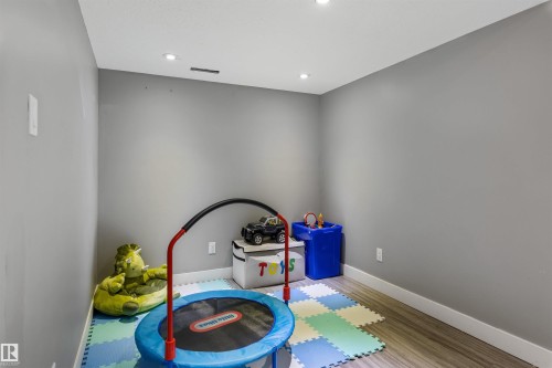 Room featuring light gray walls, recessed ceiling lighting, and wood-finish flooring - 1651 Hammond Crescent, Edmonton, AB 