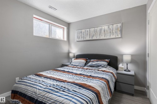 Bedroom featuring a wood-finish floor and contemporary gray walls - 1651 Hammond Crescent, Edmonton, AB 