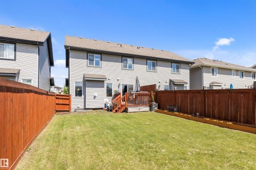 Expansive backyard featuring a manicured lawn, full privacy fencing, and a multi-level wood deck - 1651 Hammond Crescent, Edmonton, AB 
