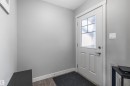Entryway featuring a white paneled door with a multi-pane frosted glass insert, brushed nickel hardware, and wood-finish flooring - 1651 Hammond Crescent, Edmonton, AB 