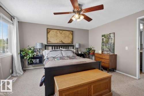 Carpeted bedroom with neutral wall tones and a window - 27 Walden Park, St. Albert, AB 