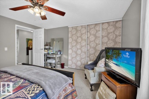 Bedroom featuring light gray walls, carpeted flooring, and a ceiling fan with integrated lighting - 27 Walden Park, St. Albert, AB 