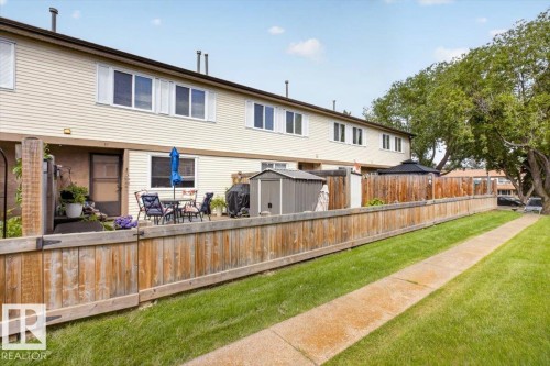 Two-story townhome featuring a private patio, light-toned siding, and a wood fence - 27 Walden Park, St. Albert, AB 