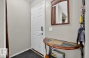 White paneled entry door with contemporary hardware and a keyless entry system - 27 Walden Park, St. Albert, AB 