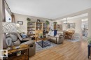 Bright interior featuring wood-finish flooring, neutral wall tones, and a dining area - 27 Walden Park, St. Albert, AB 