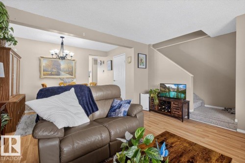 Open-concept living area featuring wood-finish flooring - 27 Walden Park, St. Albert, AB 