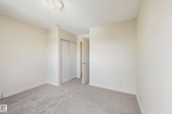 Carpeted room with sliding closet doors, white trim, and a flush-mount ceiling light - 