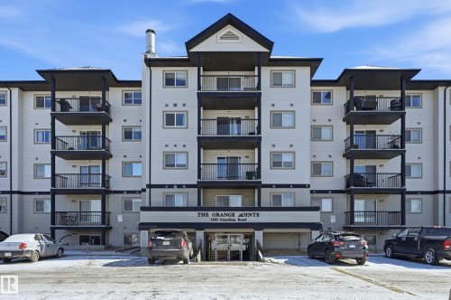Multi-story residential building with light-colored siding and dark trim - 314 2430 Guardian Road, Edmonton, AB 