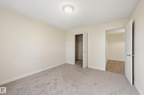 Room featuring light gray carpeting, neutral wall paint, and a built-in closet with bi-fold doors - 314 2430 Guardian Road, Edmonton, AB 