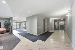 Building entryway featuring glass double doors, light-toned tile flooring, and recessed lighting - 