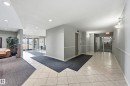 Building entryway featuring glass double doors, light-toned tile flooring, and recessed lighting - 314 2430 Guardian Road, Edmonton, AB 