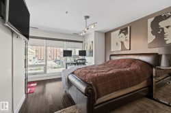 Room featuring dark wood-finish flooring and a full-wall window with roller shades - 