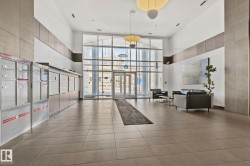 Spacious lobby featuring a soaring ceiling, floor-to-ceiling windows, large format tile flooring, and contemporary overhead lighting fixtures - 