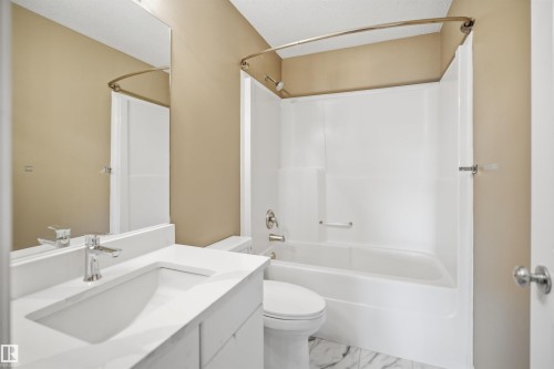 Bathroom featuring a white vanity with an integrated sink, chrome faucet, and a large wall-mounted mirror - 2610 33A Street, Edmonton, AB - Indoor Photo Showing Bathroom
