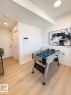 Light wood-finish flooring extending into a bright interior space - 311 32 Street, Edmonton, AB 