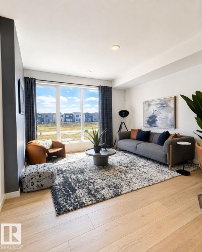 Bright living space featuring expansive windows, recessed lighting, and wood-finish flooring - 311 32 Street, Edmonton, AB 