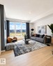 Bright living space featuring expansive windows, recessed lighting, and wood-finish flooring - 311 32 Street, Edmonton, AB 
