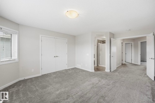 Spacious carpeted room featuring a double-door closet, a window with blinds, and recessed lighting - 33 Riviere Terrace, St. Albert, AB 