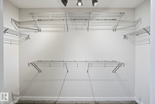 Closet featuring wire shelving system, track lighting, and carpet flooring - 33 Riviere Terrace, St. Albert, AB 