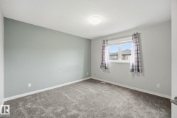 Carpeted room featuring a single window, a textured ceiling, and a flush mount ceiling light - 