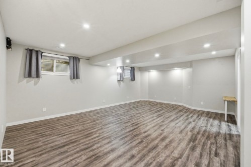 Spacious room featuring wood-finish flooring, recessed lighting, and light grey painted walls - 33 Riviere Terrace, St. Albert, AB 