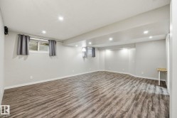Spacious room featuring wood-finish flooring, recessed lighting, and light grey painted walls - 