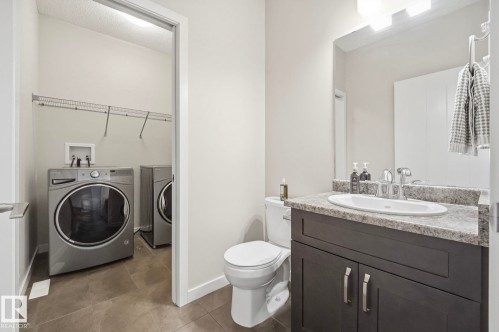 Bathroom featuring a dark wood-finish vanity with a speckled countertop and an undermount sink - 33 Riviere Terrace, St. Albert, AB 