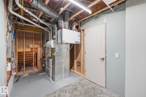Utility room featuring a furnace, water heater, and exposed overhead ductwork - 33 Riviere Terrace, St. Albert, AB 
