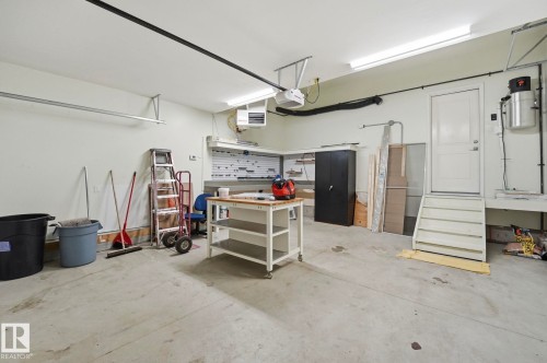 Concrete floor garage with ample wall space, overhead lighting, and an overhead garage door track system - 33 Riviere Terrace, St. Albert, AB 