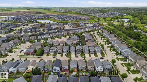 Aerial perspective of a developed residential neighborhood featuring a variety of single-family homes with dark roofs - 33 Riviere Terrace, St. Albert, AB 