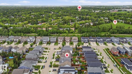 Residential development featuring a variety of detached and attached homes with gray and blue siding, dark-toned roofs, and paved streets - 33 Riviere Terrace, St. Albert, AB 