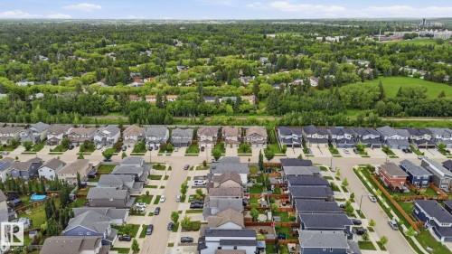 Aerial perspective showcasing a developed residential neighborhood with a variety of single-family homes, complemented by extensive surrounding greenery - 33 Riviere Terrace, St. Albert, AB 