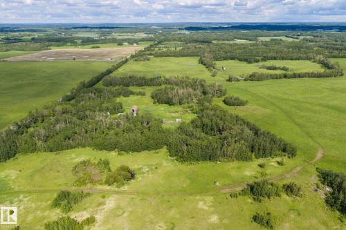 Expansive green landscape featuring varied terrain, including open fields and wooded areas - 23327 Twp Rd 510, Rural Leduc County, AB 