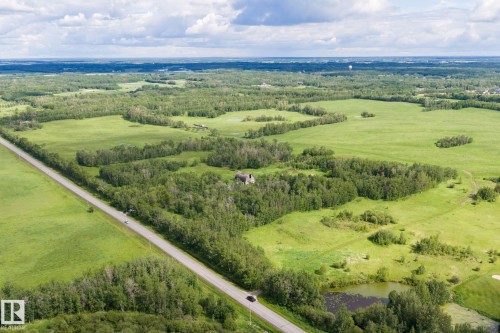 Expansive aerial view showcasing a significant land parcel with a paved road frontage - 23327 Twp Rd 510, Rural Leduc County, AB 