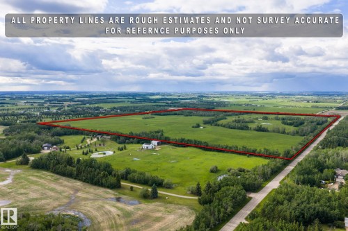 Expansive land parcel featuring open fields, wooded areas, and a visible pond - 23327 Twp Rd 510, Rural Leduc County, AB 