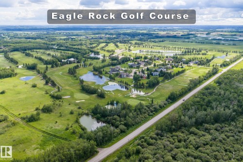 Expansive aerial showcasing a golf course community with multiple residential properties - 23327 Twp Rd 510, Rural Leduc County, AB 