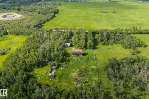 Expansive land parcel featuring an established dwelling, outbuildings, and a surrounding of mature trees - 23327 Twp Rd 510, Rural Leduc County, AB 