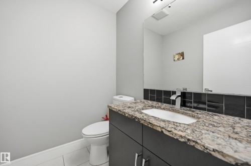 Vanity with granite countertop, integrated sink, and modern faucet - 5430 Edworthy Way, Edmonton, AB - Indoor Photo Showing Bathroom