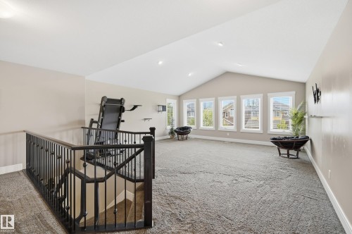 Spacious upper-level loft featuring vaulted ceilings, recessed lighting, and multiple windows - 5430 Edworthy Way, Edmonton, AB - Indoor Photo Showing Other Room