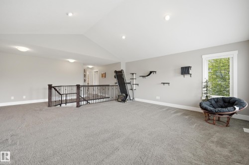Spacious carpeted open-concept bonus room featuring a vaulted ceiling with recessed lighting - 5430 Edworthy Way, Edmonton, AB - Indoor Photo Showing Other Room