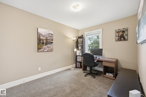 Carpeted room featuring a white-trimmed window, neutral wall paint, and white baseboards - 5430 Edworthy Way, Edmonton, AB - Indoor Photo Showing Office