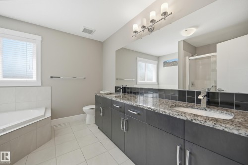 Bathroom featuring a corner soaking tub, dual vanity with granite countertop, and a tiled shower enclosure - 5430 Edworthy Way, Edmonton, AB - Indoor Photo Showing Bathroom