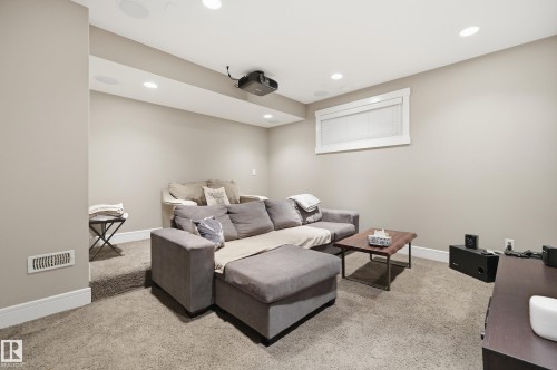 Entertainment space featuring recessed lighting, a ceiling-mounted projector, and neutral-toned carpeting - 5430 Edworthy Way, Edmonton, AB - Indoor