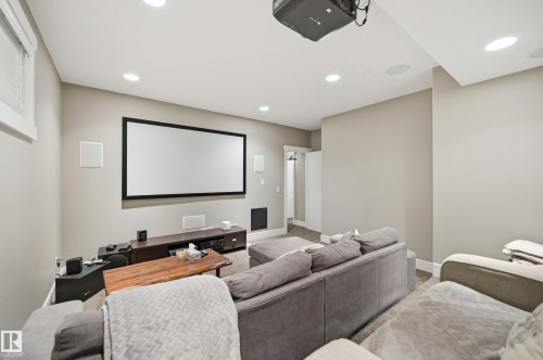 Dedicated media room featuring a large projection screen, ceiling-mounted projector, recessed lighting, wall-mounted speakers, and light neutral wall finishes - 5430 Edworthy Way, Edmonton, AB - Indoor Photo Showing Other Room